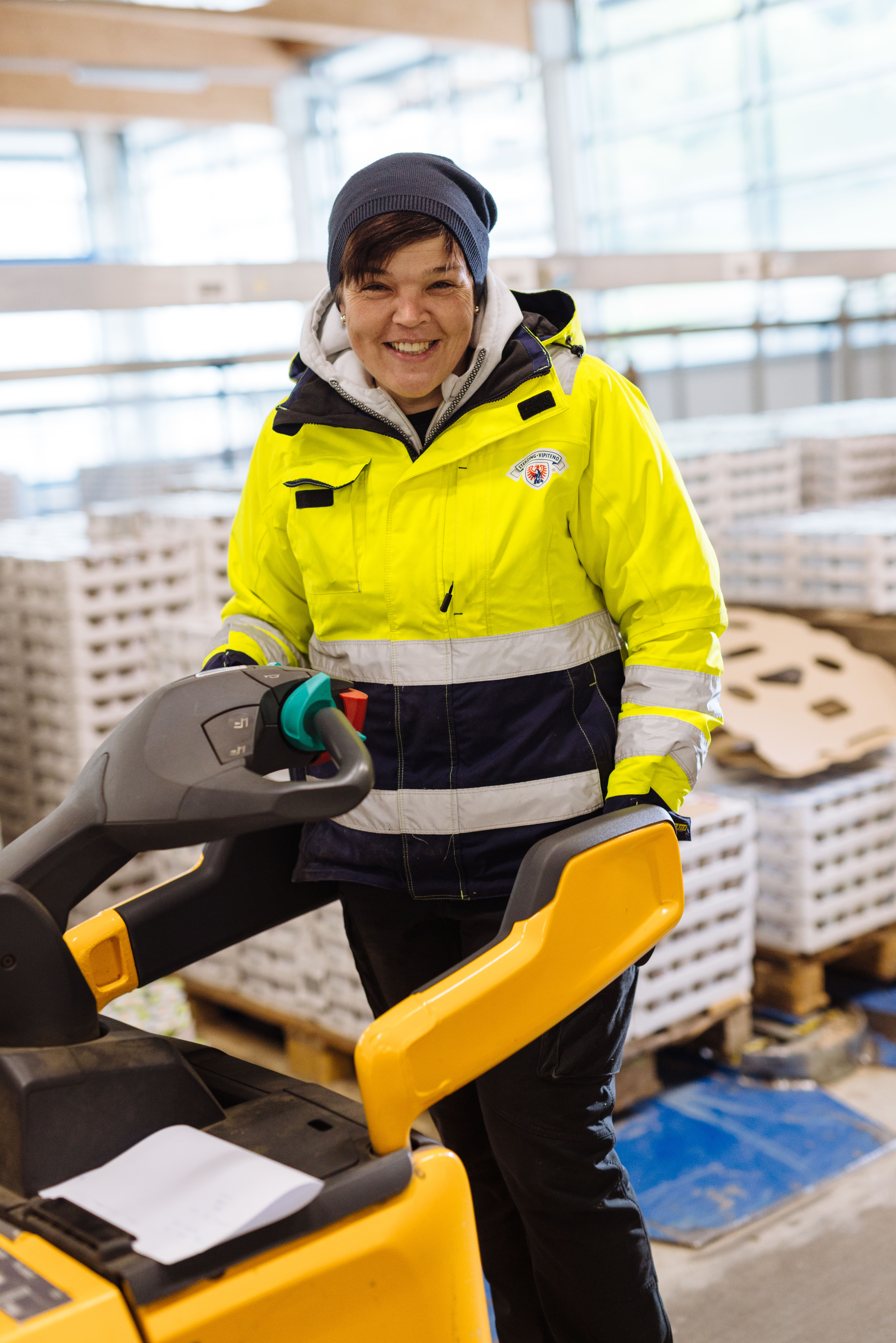 Magazin-Mitarbeiter mit gelber Weste auf einem Stapler.