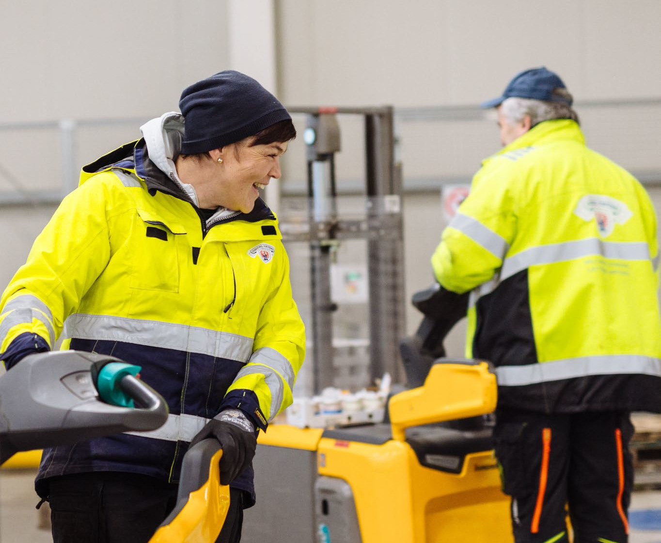Mitarbeiter in Schutzkleidung bedient eine Maschine in einer Industriehalle